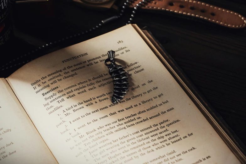 an open book next to a chain and a watch