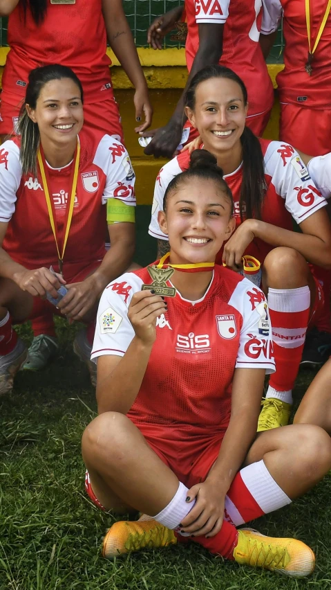 a group of women soccer players wearing red uniform pose for a picture