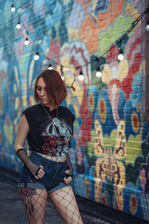 a woman standing next to a wall with a fishnet and net garter