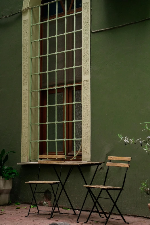 a table with two chairs near by and a window