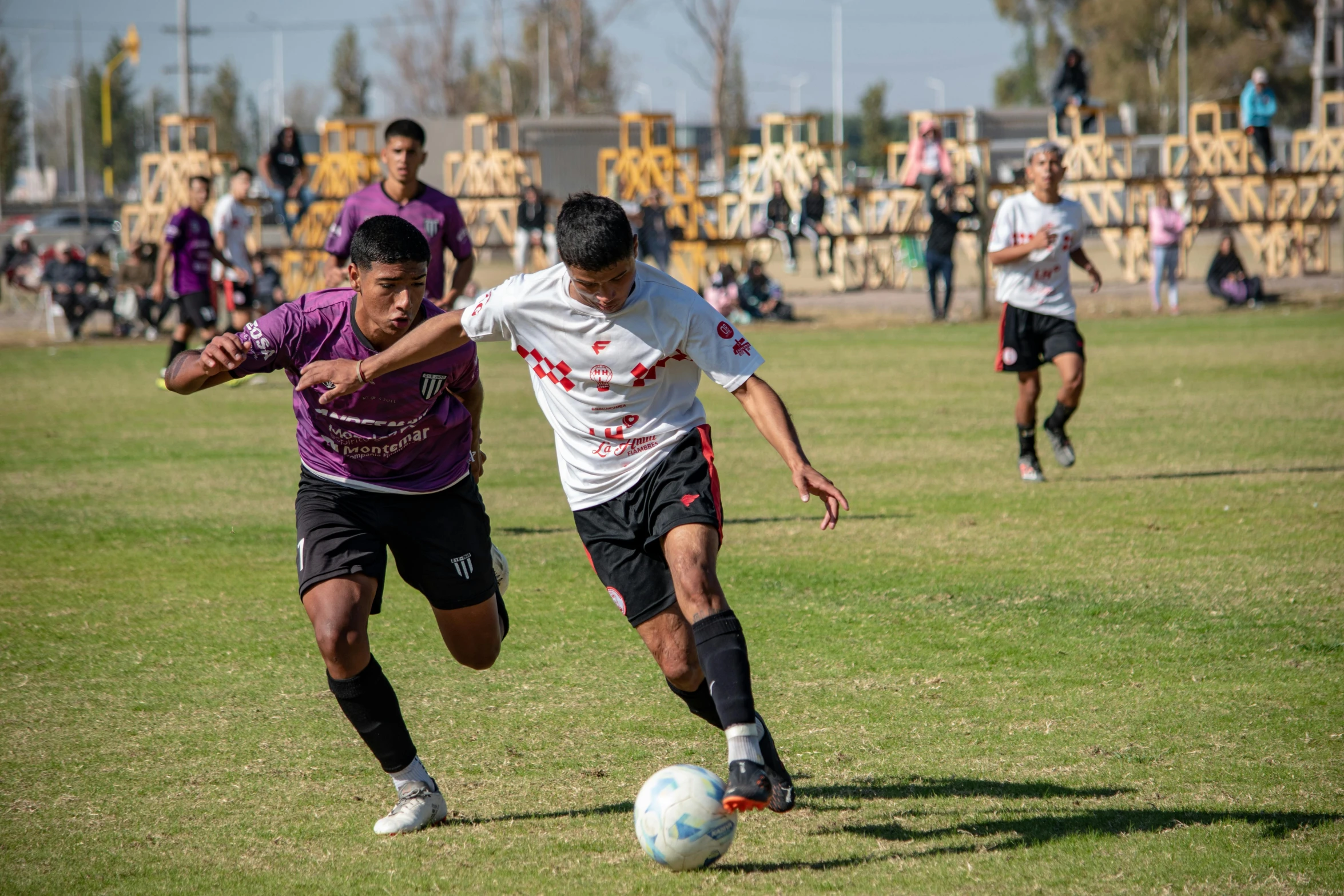 two young men play soccer in a park