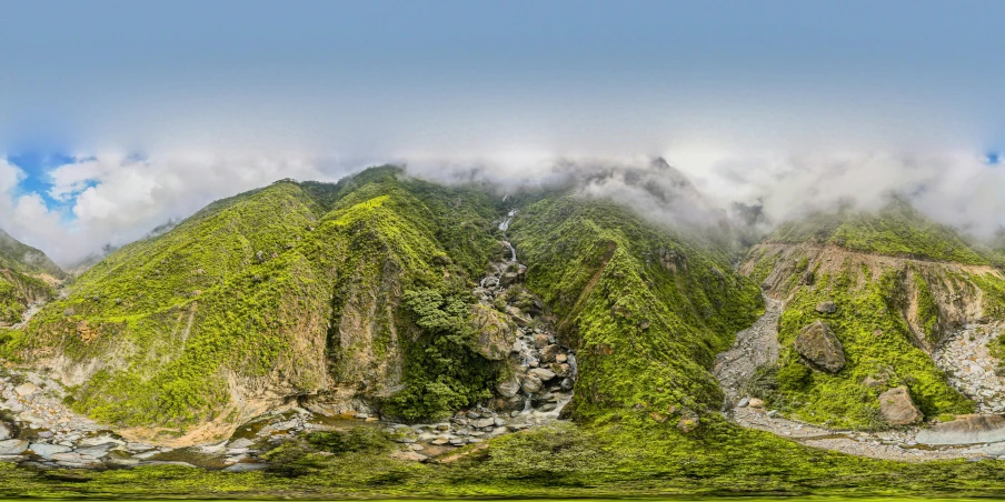 green mountain with trees and clouds in background