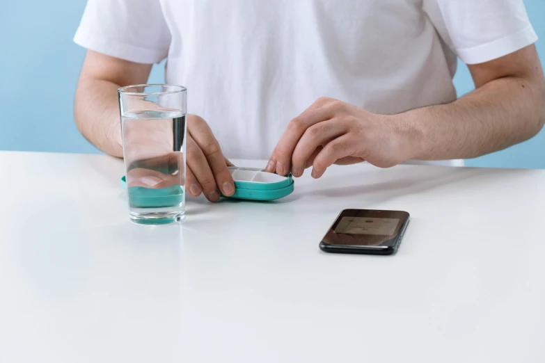 man is putting soing into a small cup on a table