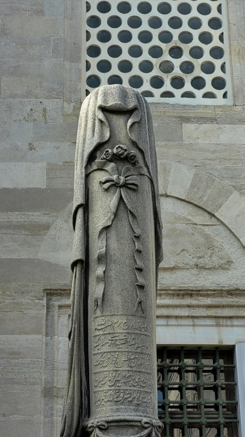 a large stone headless sculpture near an old brick building