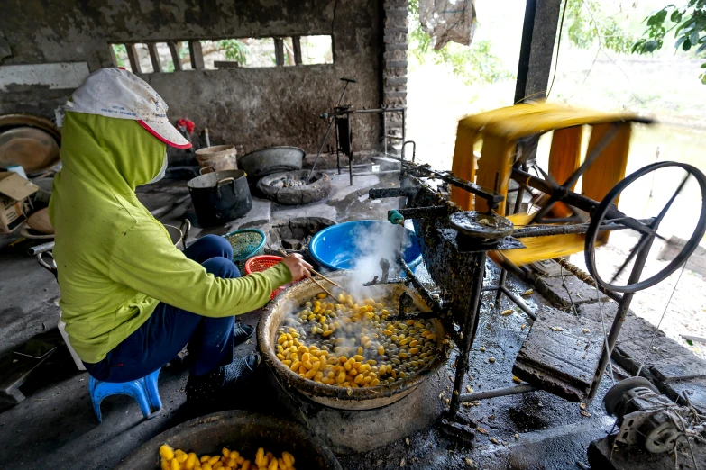 a lady is cooking corn in a small kitchen