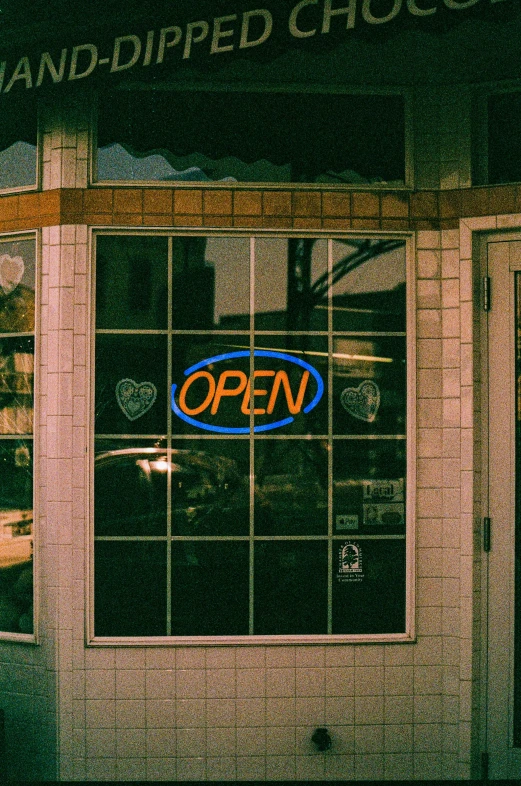 a window at a business displaying the word open