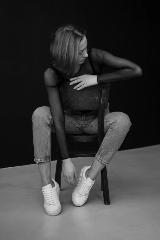 a woman is sitting on a chair with her arms crossed