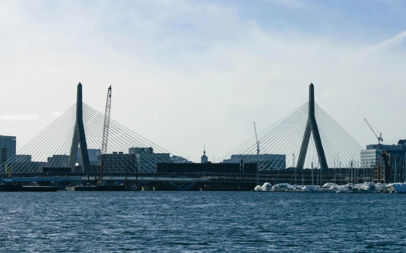 the sailboats are sailing in the water near the large bridge