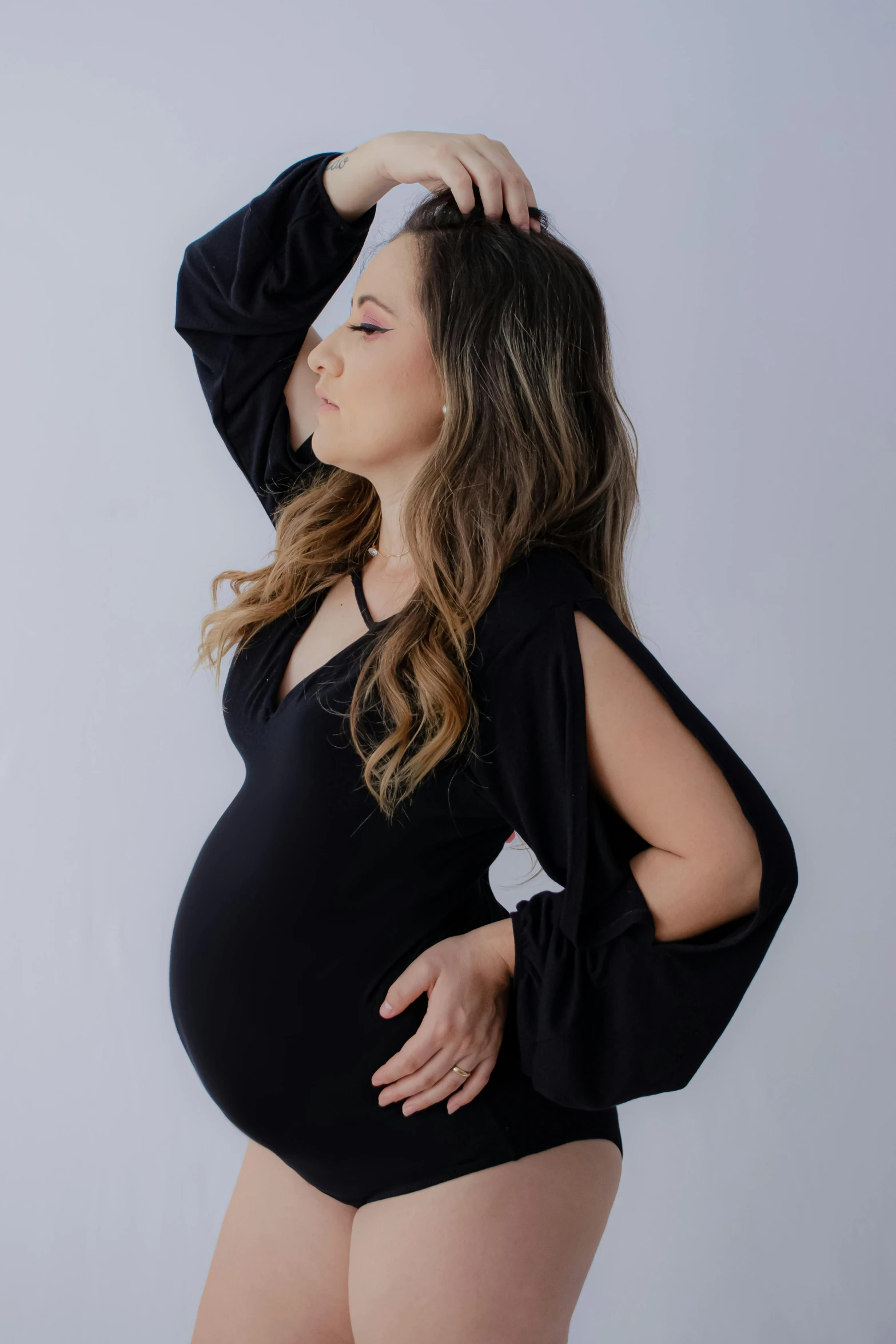 a pregnant woman in black and posing for the camera