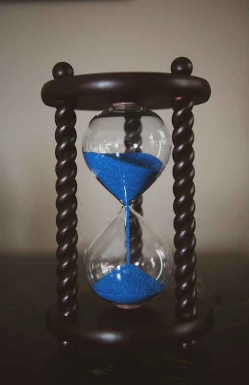 a sand glass sits on a table in the evening