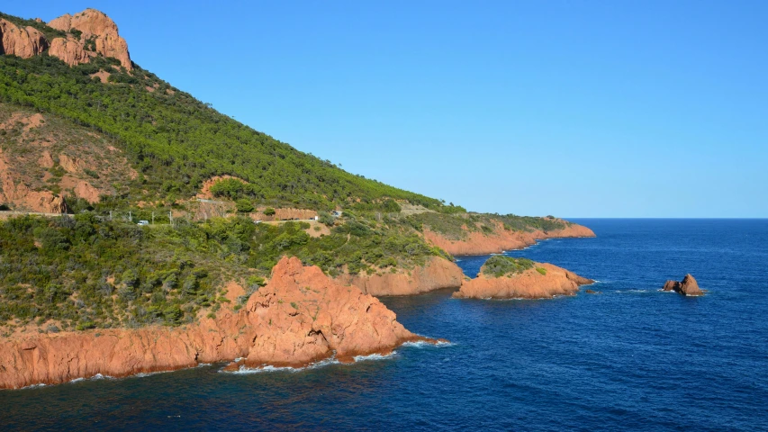 a scenic view of two small rock formations next to an ocean