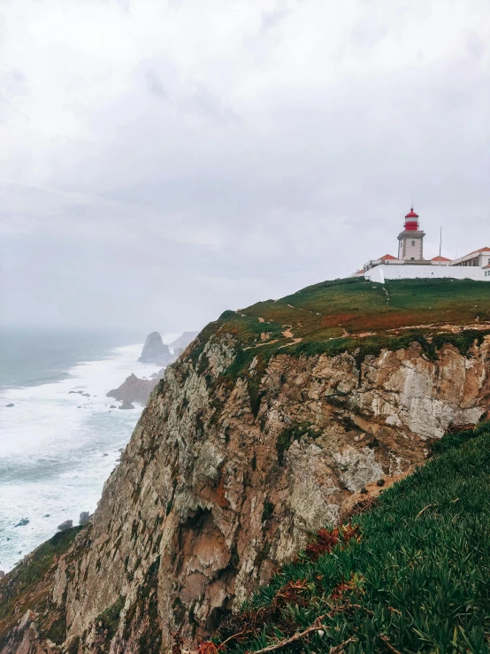 a lighthouse at the top of a cliff overlooking the ocean