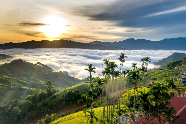 the sun shines through the clouds on top of a hill