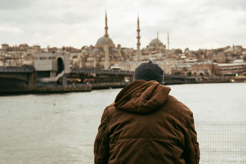 a person wearing a jacket looking out over the water