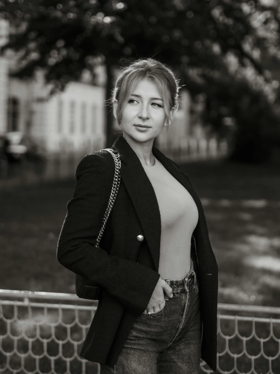 a woman that is leaning up against a fence