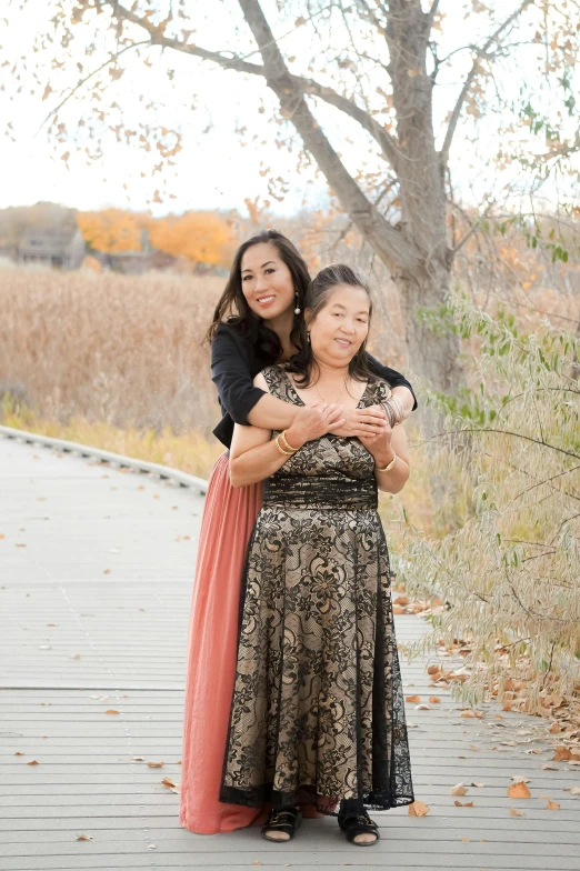 an older woman hugging a younger woman on a boardwalk