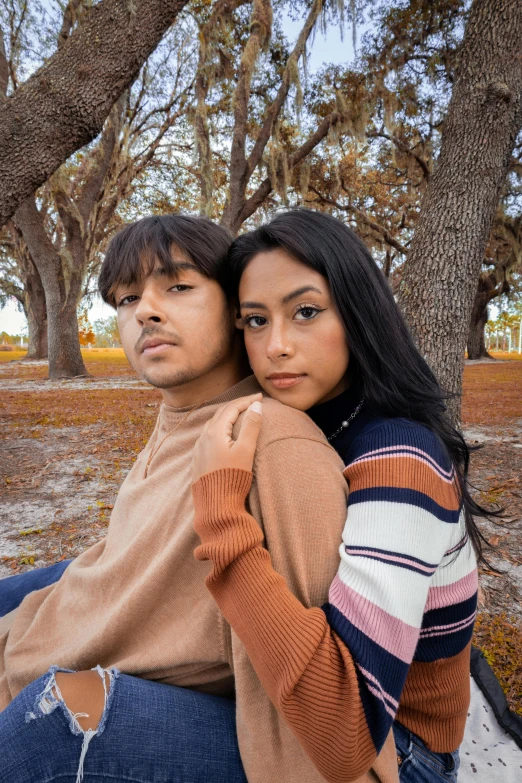 a man sitting next to a woman on a rock