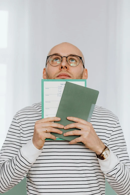 a man is holding papers up to his face