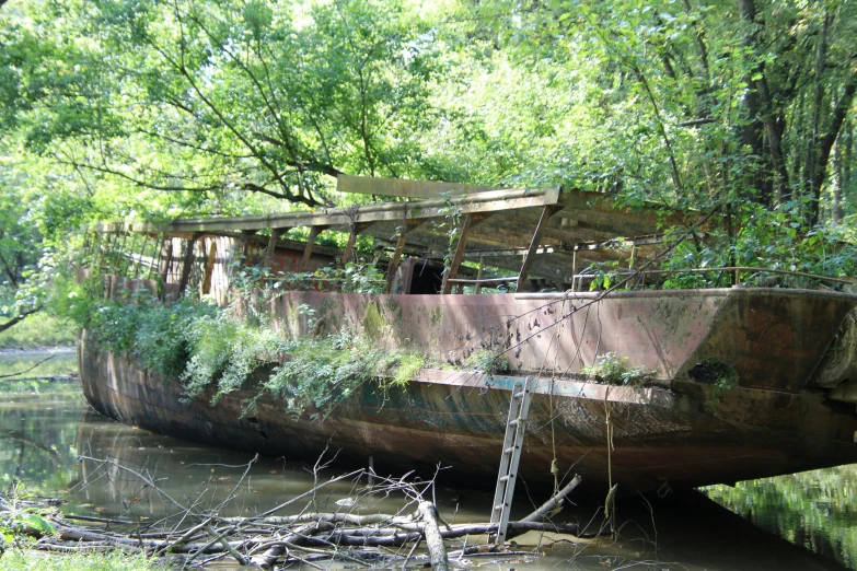 an abandoned boat sitting in the middle of some water