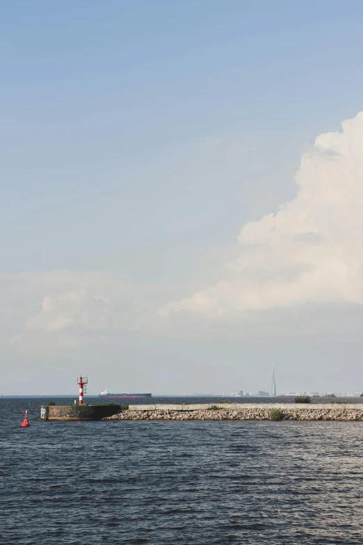 a lighthouse on the water during a cloudy day