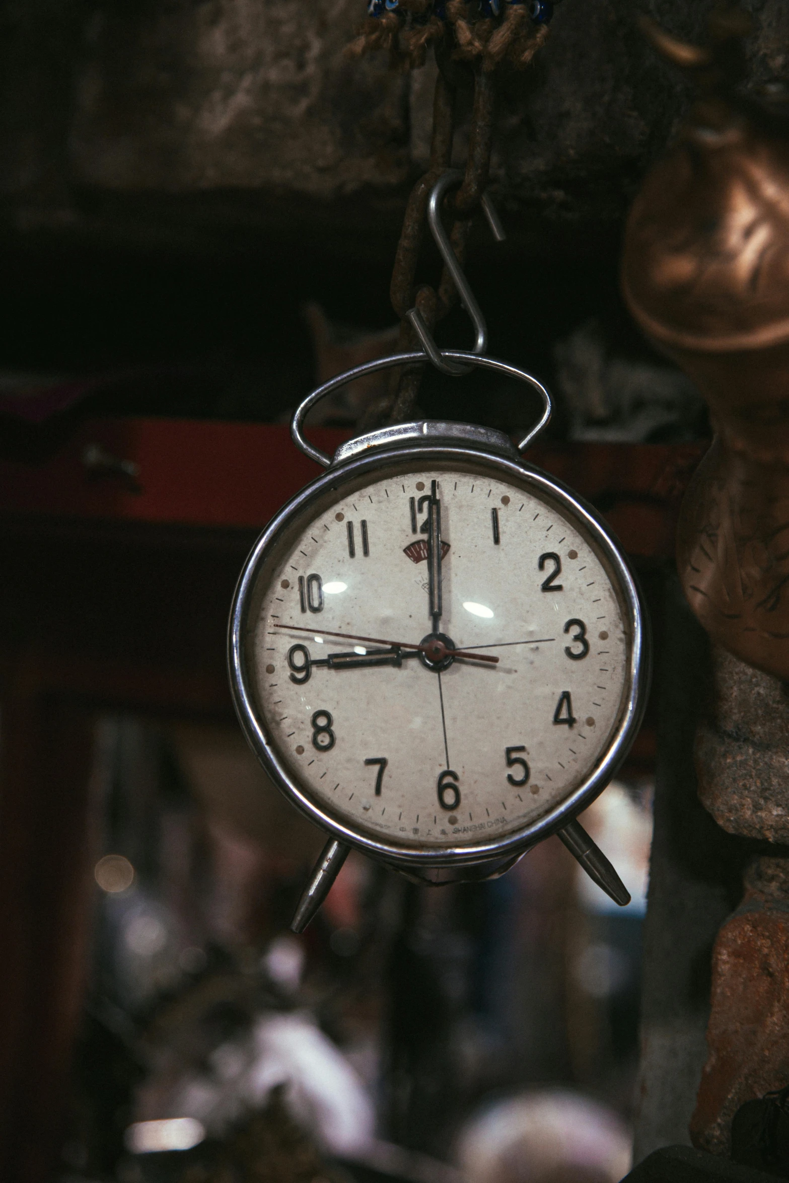 a clock hanging upside down with metal hands