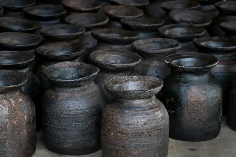 black pottery bottles lined up neatly in rows