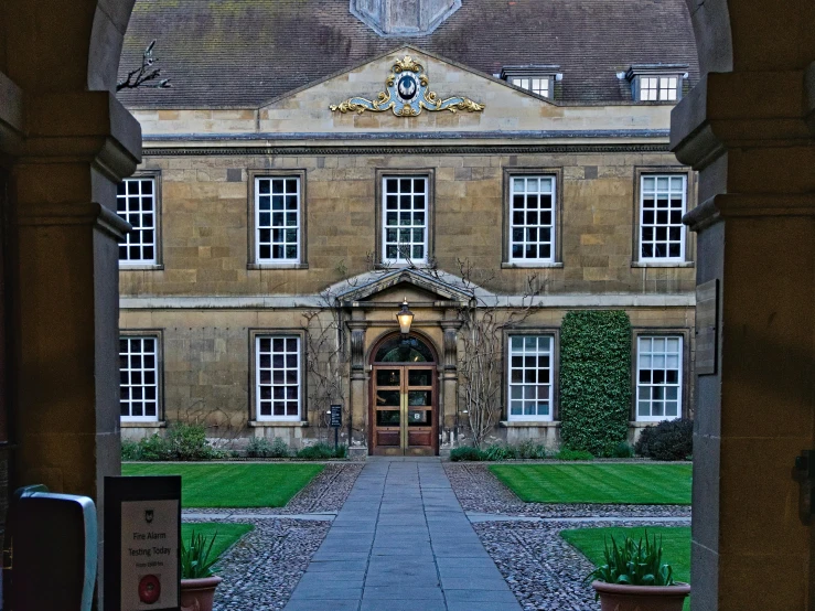 an archway leading to a large building with several windows