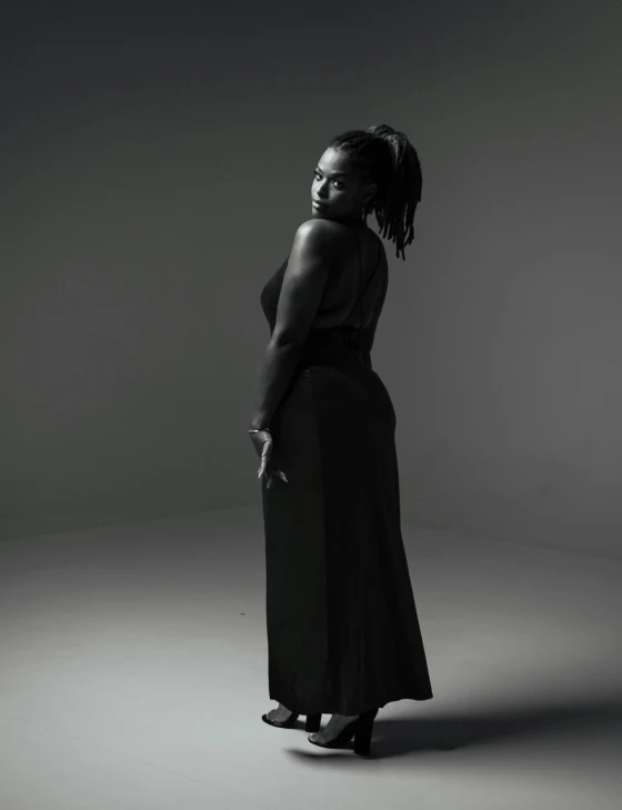 a woman is standing on a grey background