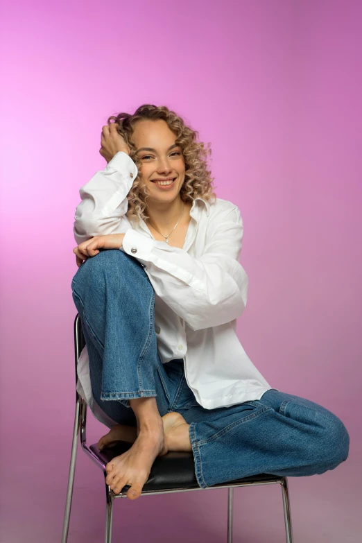 a young woman sitting on top of a chair holding a baby