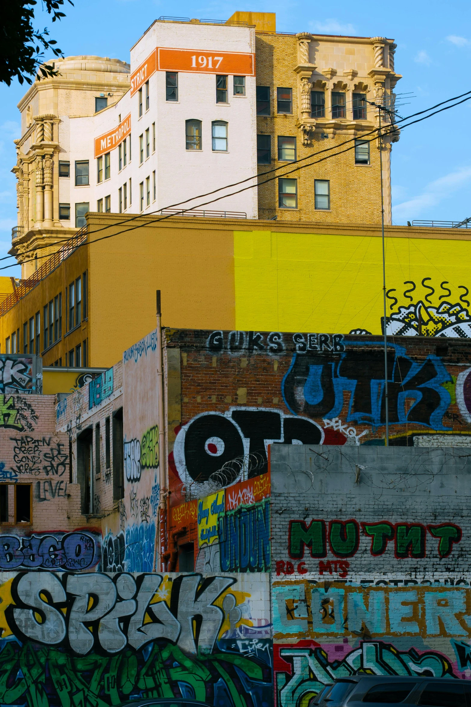 a bunch of colorful graffiti covering buildings on a sunny day