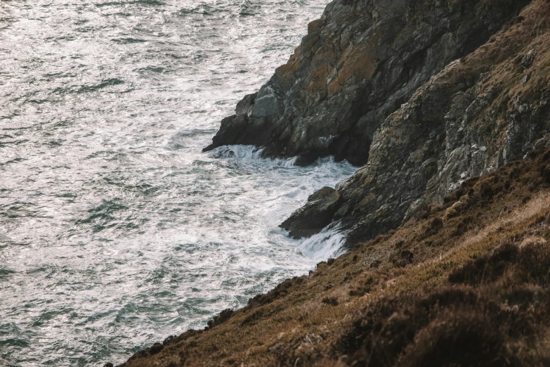 some rocks and grass by the water