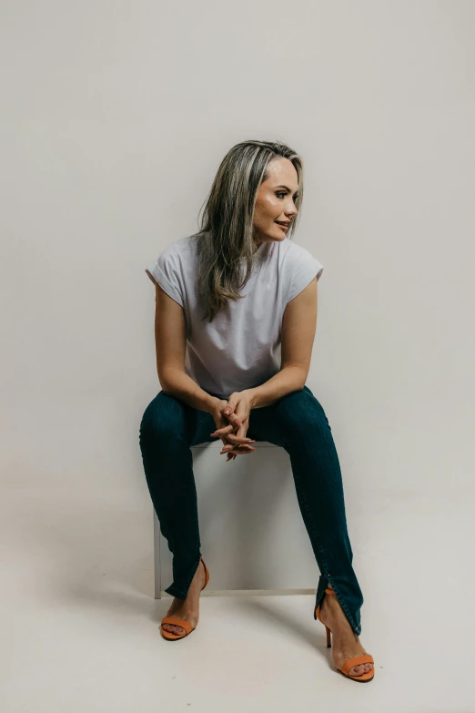 a woman with her legs crossed sits in the center of a po