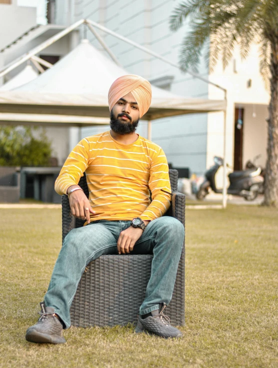 a man sitting in an armchair that has a hat on his head