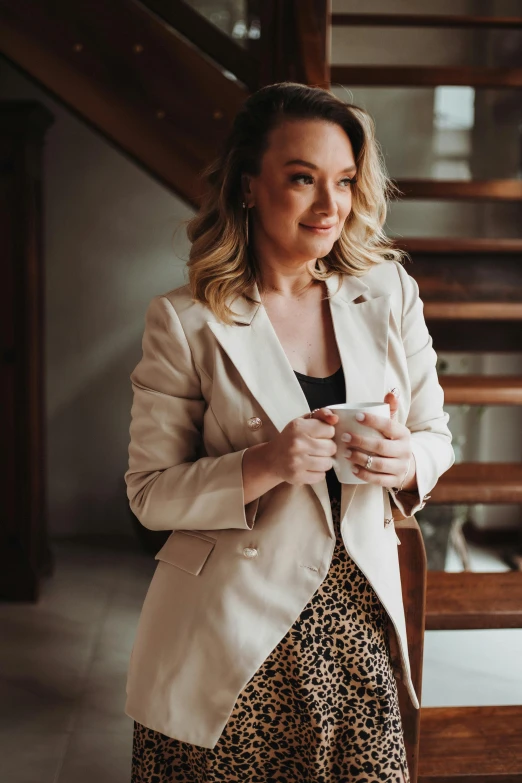 a woman standing under a staircase and holding a phone