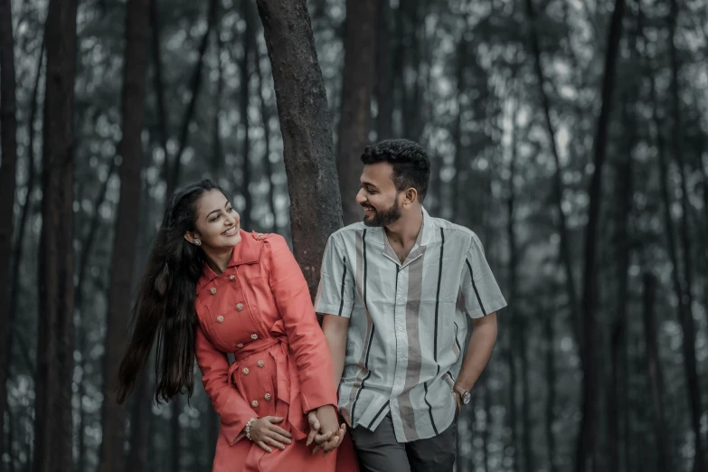 a couple walking through the woods holding hands