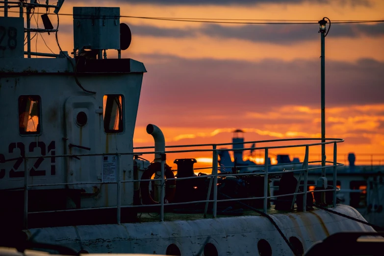 a ship is docked and in silhouette at sunset