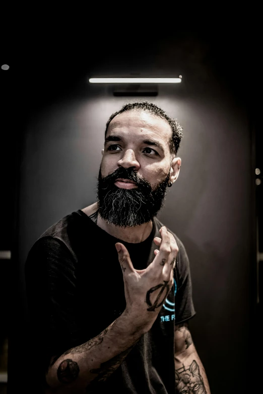 a man with a tattooed face and hands folded in prayer