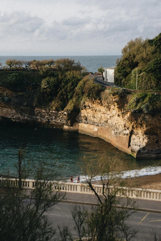 a scenic view of an ocean along side of a mountain