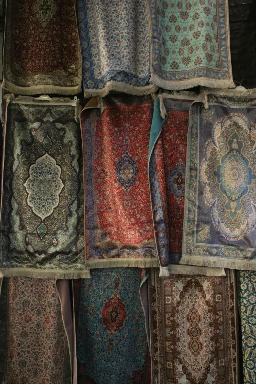 a pile of oriental rugs sitting on display in a room