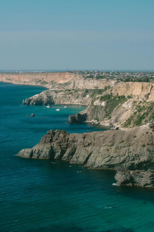 a view of some blue water next to some cliffs