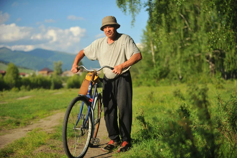 a man is holding up his bike on the side of the road