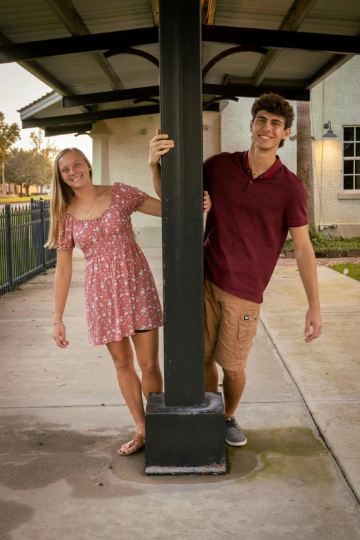 there are two people standing near a pole