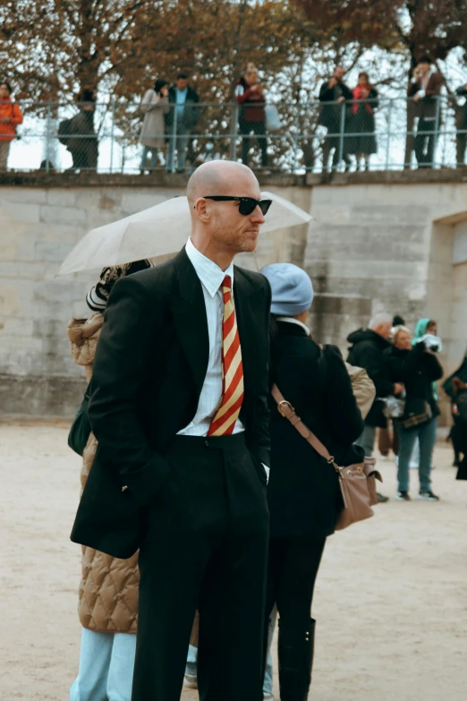 an older man is wearing a red and orange striped tie