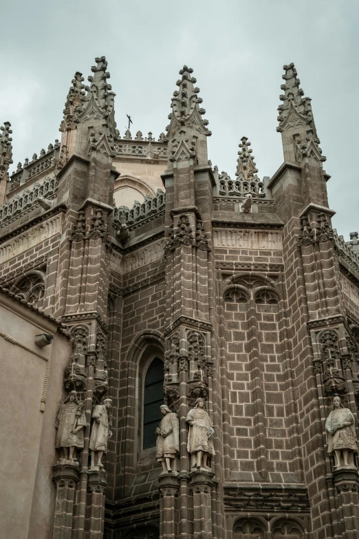 an old church with stone statues and a clock