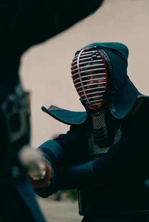 the man is wearing a dark green outfit and a red vent mask