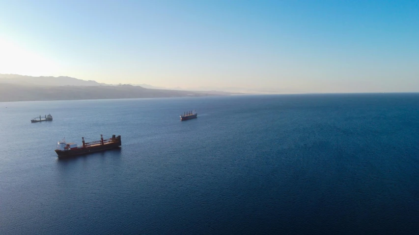 three ships floating out on top of the ocean