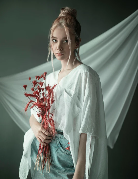 a woman holding a bunch of flowers wearing a white shirt