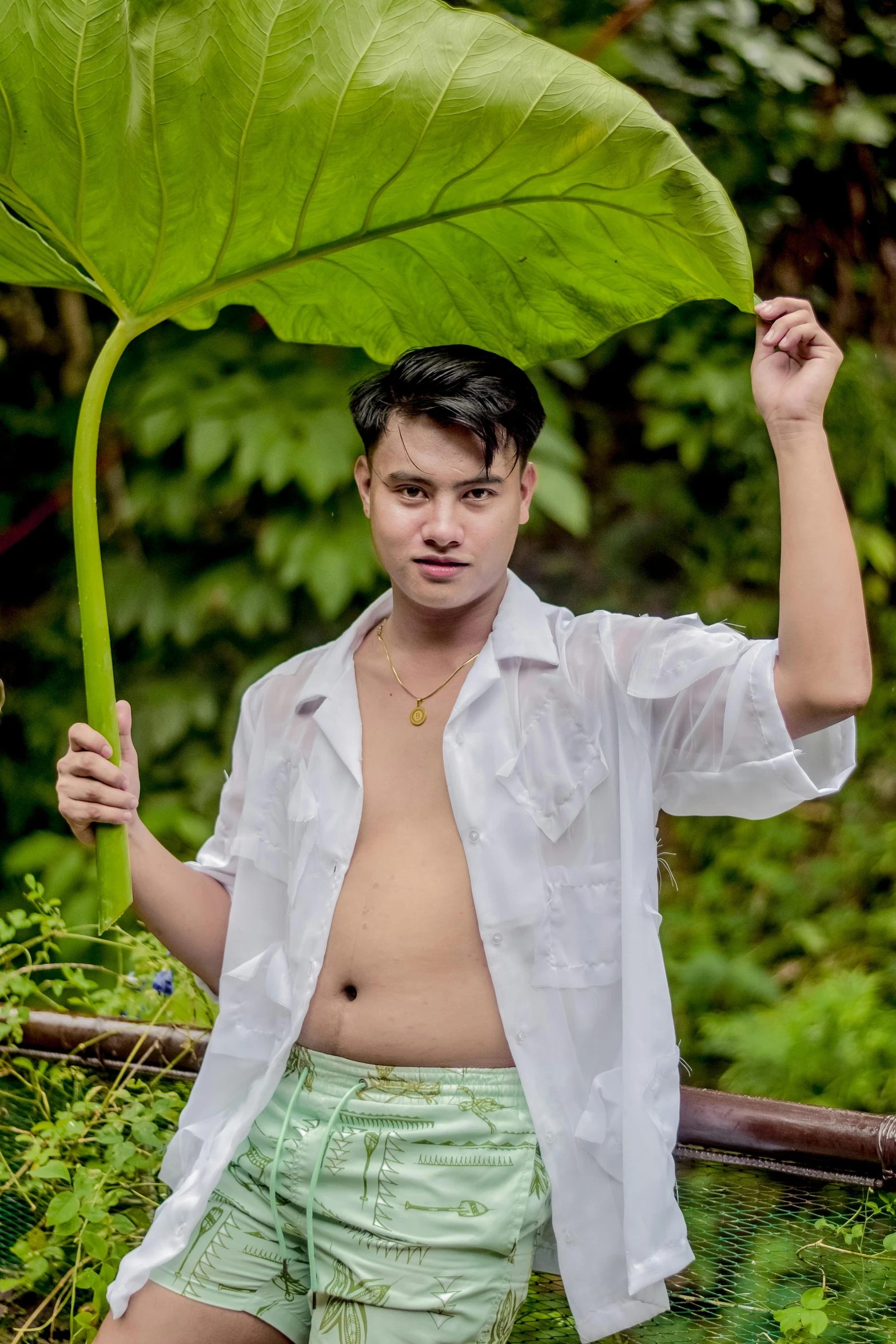 a man with his shirt open, with a large leaf on his back