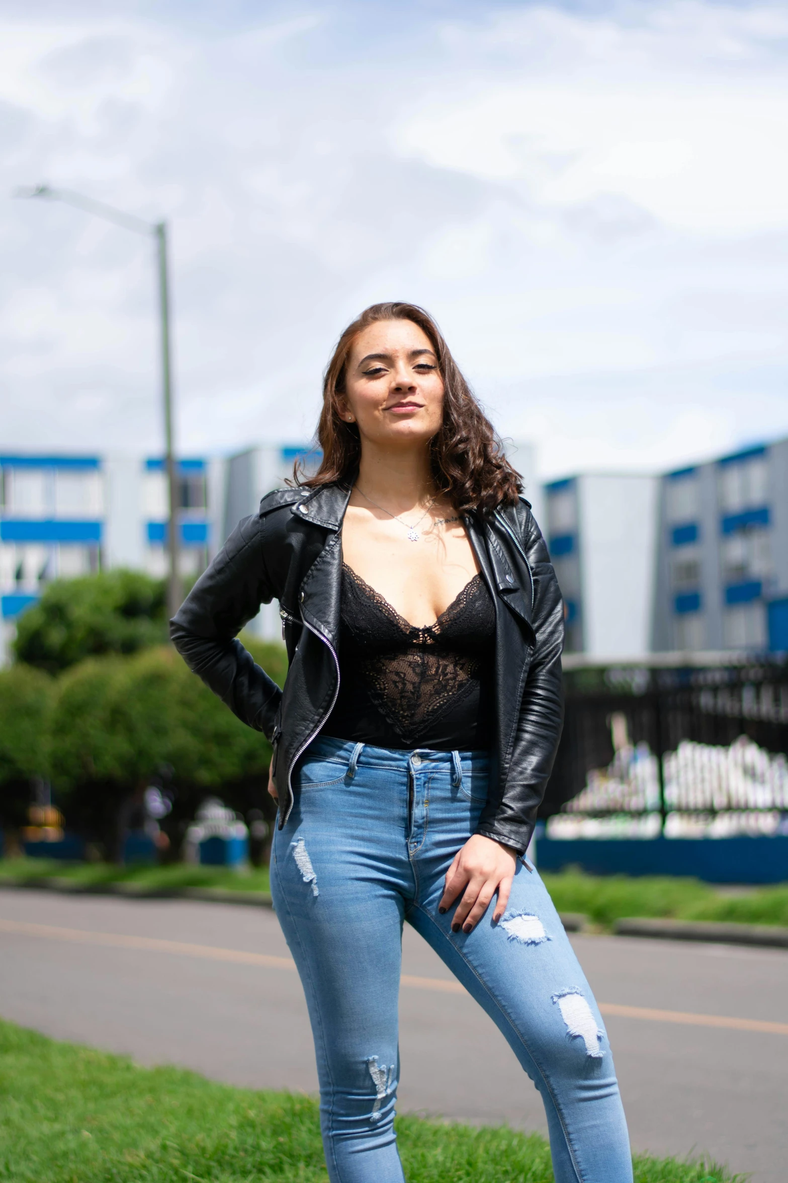 a young woman posing on the sidewalk outside