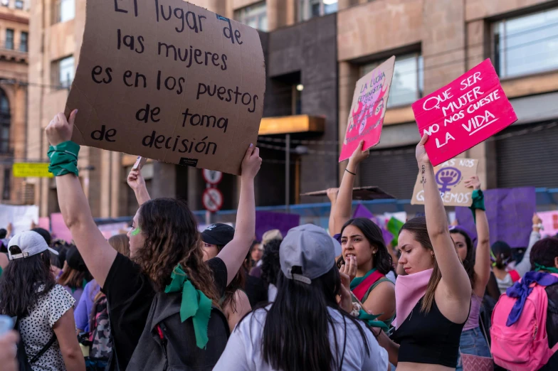 there are many women holding signs on the street